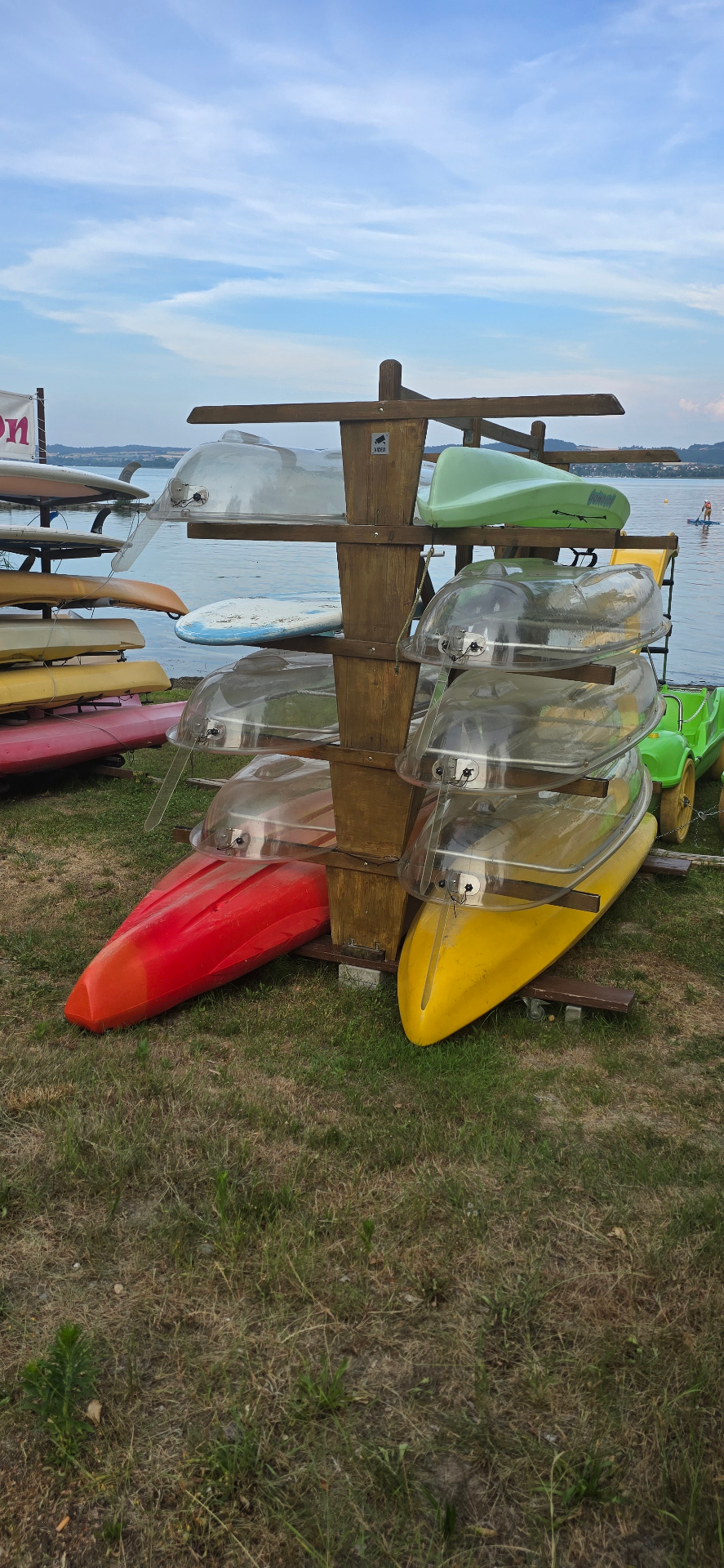 Kayaks stockés sur un rack en bois ouvert au bord de l'eau